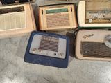 many old radio ' s sitting on the floor next to each other