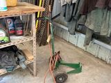 un petit chariot contenant un tuyau et d'autres objets dans un garage