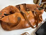a brown purse sitting on top of a table next to a pair of shoes