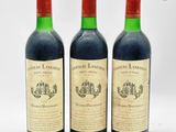 trois bouteilles de vin rouge posées l'une à côté de l'autre sur une surface blanche