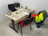a desk with two chairs and a table with a laptop on it
