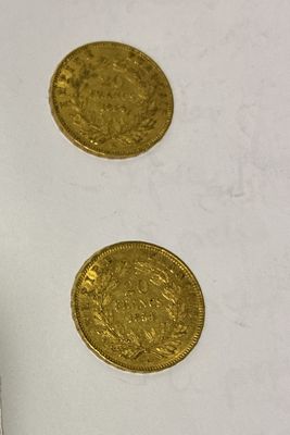 three gold coins sitting on a table next to each other
