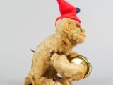 un petit ours en peluche avec un bonnet rouge et une clochette