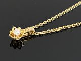 a close up of a gold necklace on a black surface