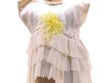 une robe sur un mannequin, ornée d'une fleur jaune