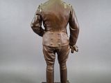 bronze statue of a man in a military uniform holding a gun