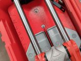 a red tool box with tools in it and a person standing next to it