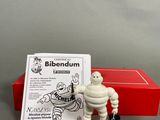 the figurine is sitting next to a red box