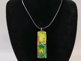 a necklace with a green and yellow painting on it