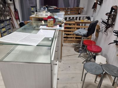 une vitrine en verre au milieu d'une pièce où se trouvent des tabourets