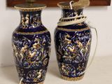 deux vases bleus posés sur une table à côté d'un tableau