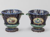 une paire de vases bleus et verts sur lesquels est représenté un homme et une femme