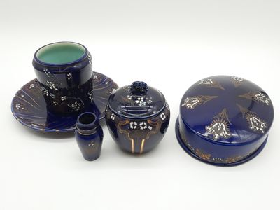 Plusieurs pièces de poterie bleue sont posées sur une surface blanche