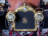 a close up of an old fashioned car with a clock on the front of it