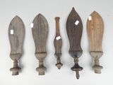 four wooden knives are lined up against a white wall