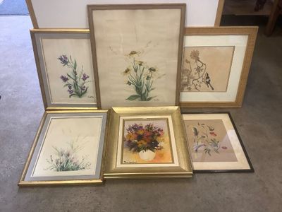 quatre photos encadrées représentant des fleurs et des plantes sont posées par terre