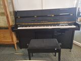 a black piano and a stool in a room