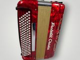 an old red accordion hanging on a white wall