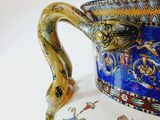 a blue and yellow vase with a snake on it