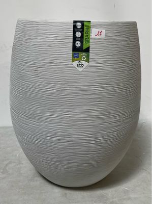 un grand vase blanc posé par terre