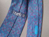 blue tie with pink and blue designs on it on a gray surface