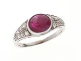 un gros plan d'une bague sertie d'un rubis et de diamants