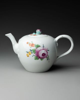 un gros plan d'une théière blanche décorée de fleurs