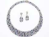 une photo d'un ensemble composé d'un collier et de boucles d'oreilles posé sur un fond blanc