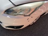 a close up of a white car with a denting on it