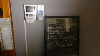 un tableau noir sur lequel est inscrit un menu, à côté d'un téléphone