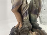 a statue of a woman holding a fish on a rock