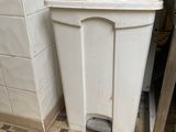 une poubelle blanche posée dans un coin de la cuisine