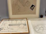 deux dessins encadrés posés l'un à côté de l'autre sur une table