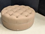 the large round ottoman is sitting on the floor in the corner of the room