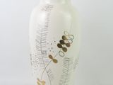 a white vase with a black lid sitting on a white surface