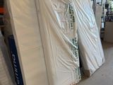 many mattresses stacked up in a warehouse with pallets