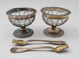 deux plats en argent et une cuillère posés sur une table