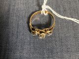 un gros plan d'une bague en or posée sur un tissu bleu