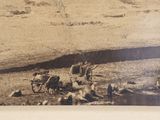 an old photo of a horse drawn wagon on the side of the road