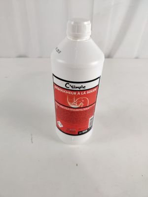 une bouteille contenant un liquide rouge posée sur une table blanche