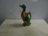 a small ceramic duck that is sitting on a table