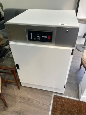 a white dishwasher sitting in a kitchen next to a chair