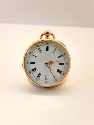 une petite montre de poche en or avec des chiffres romains