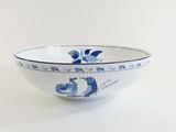 a blue and white bowl sitting on a white table