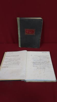 an open book sitting on top of a red cloth covered table