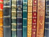 many books that are lined up together on a shelf