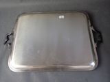 an old silver tray with a handle on a table
