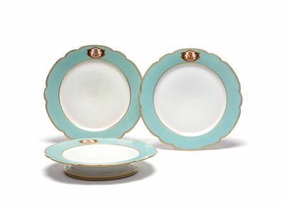 deux assiettes bleues et blanches, ornées de bordures dorées sur fond blanc