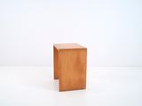 a small wooden stool sitting on top of a white floor