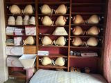 un lit dans une chambre où se trouve une étagère remplie de vases